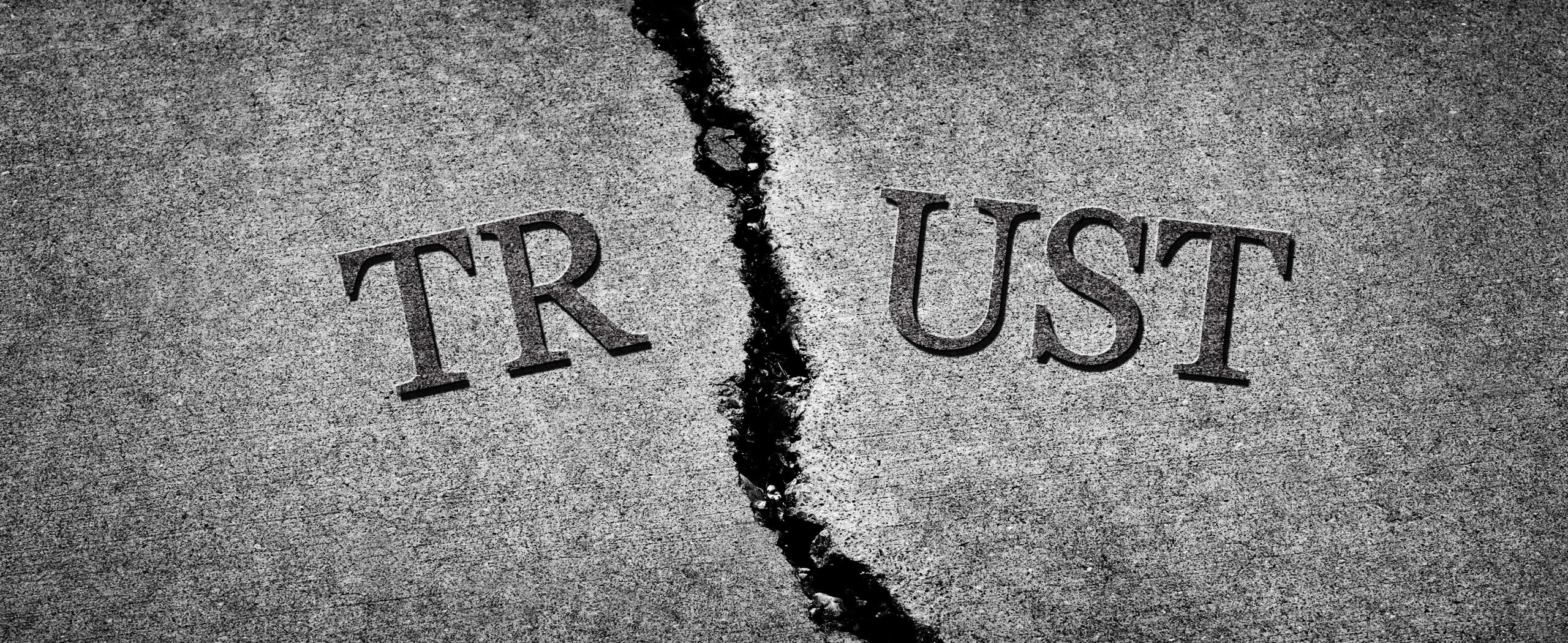 The word TRUST on cloth ripped in half